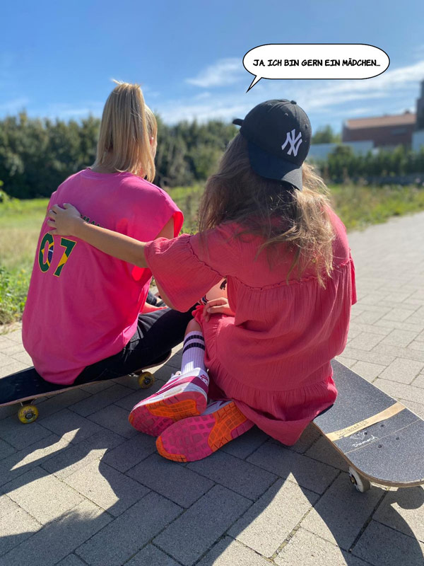 zwei Mädchen sitzen jeweils auf einem Skateboard, Rücken zur Kamera © Caro aus dem JIZ