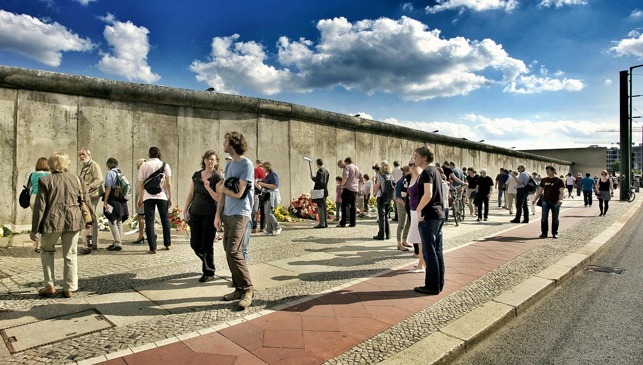 Menschen stehen verteilt vor der Berliner Mauer. © LoboStudioHamburg by pixabay