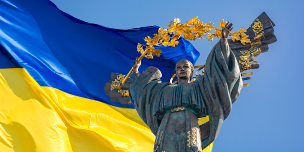 Unabhängigkeitsdenkmal in Kiew vor ukrainischer Flagge © Valentin Kundeus/Adobe Stock